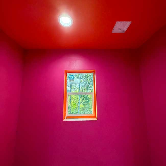 Potty small room with vibrant pink walls and orange ceiling