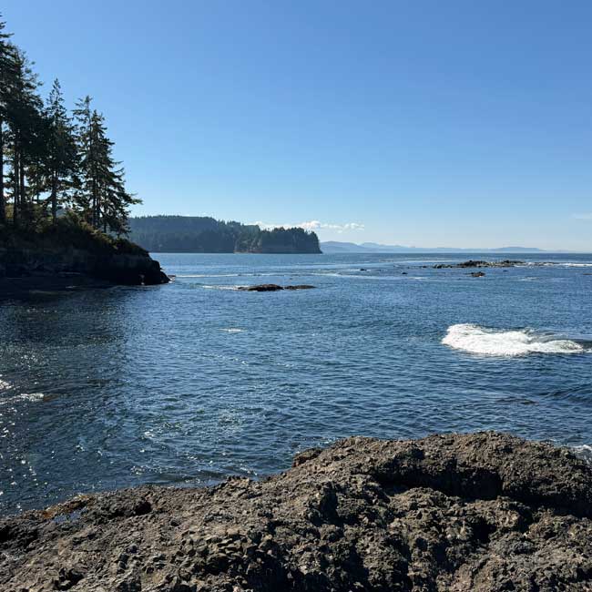 Layers of rocky shoreline, blue water and distant headlands at Salt Creek Recreation Area, WA